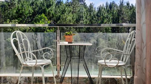 two chairs and a table on a balcony at NEST House in Ấp Kim Thạch