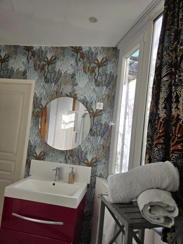 une salle de bain avec un lavabo et un miroir dans l'établissement Bel appartement, à Beaune