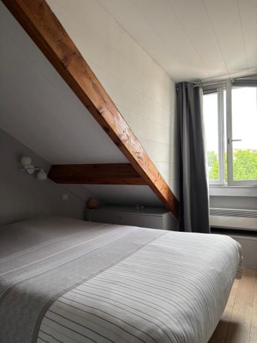 - une chambre avec un lit et un toit en bois dans l'établissement Charme et confort au cœur de Versailles, à Versailles