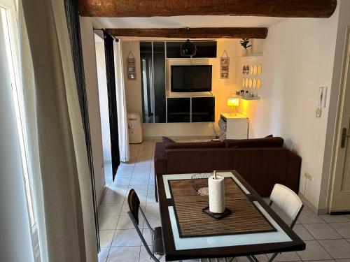 - un salon avec un canapé et une table avec une bougie dans l'établissement Appartement-Studio, à Sérignan