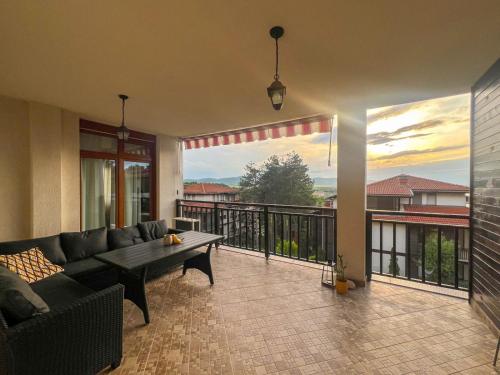 a living room with a couch and a table on a balcony at Lavender Apartment in Sozopol