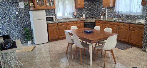 a kitchen with a wooden table and white appliances at Ribeiro´s House in Gafanha da Nazaré