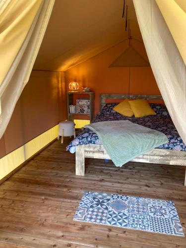 a bedroom with a bed in a tent at Écolodge safari in Chazelles