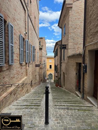 an empty alley in an old town with buildings at La Dimora del Borgo in Montecassiano