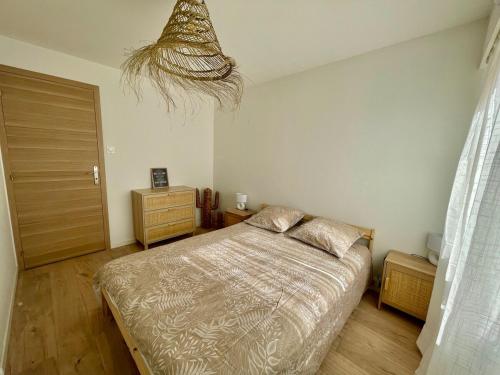 une chambre avec un lit et un parquet dans l'établissement De la pinède a la plage vue mer, à Saint-Mandrier-sur-Mer