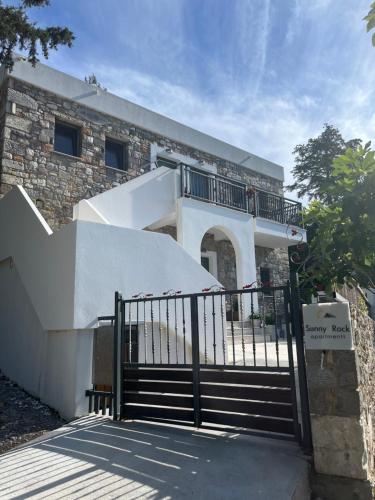a building with a gate and stairs in front of it at Sunny Rock Apartments in Asfendioú