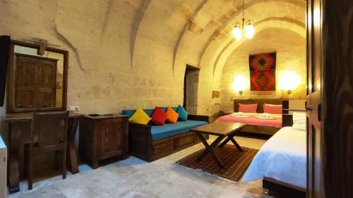 a bedroom with a bed and a couch in a room at ARMEsos Cave Hotel in Urgup