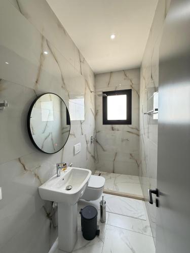 a white bathroom with a sink and a mirror at Villa Papa-Berat in Berat