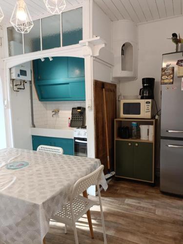 une petite cuisine avec une table et un réfrigérateur dans l'établissement maison Madeleine, à Saint-Gilles-Croix-de-Vie