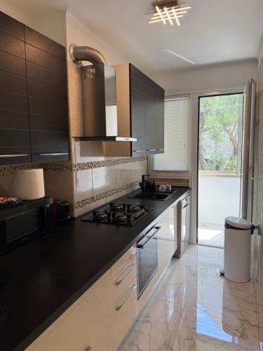 - une cuisine équipée de comptoirs noirs et d'une cuisinière four supérieur dans l'établissement Emotion Vip Apartment, à Nice
