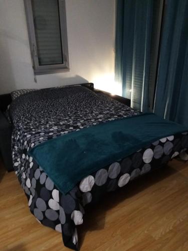 - un lit avec une couette en noir et blanc dans l'établissement Appartement avec garage et grande terrasse , proximité des plages, à La Grande Motte
