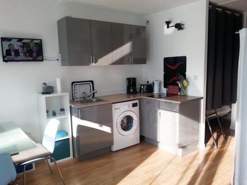 une cuisine avec une machine à laver et un lave-linge dans l'établissement Appartement avec garage et grande terrasse , proximité des plages, à La Grande Motte
