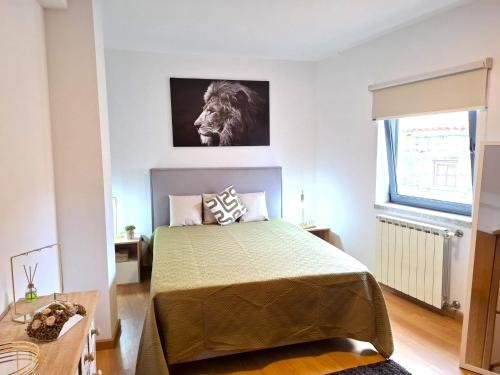 a bedroom with a bed and a picture of a lion on the wall at Casa Dos Passos II in Guarda