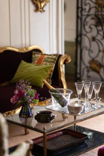 une table basse en verre avec des verres à vin sur un canapé dans l'établissement Château de LARNAGOL, à Larnagol