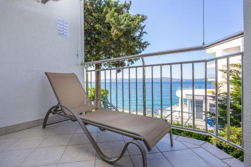 a chair on a balcony with a view of the ocean at Apartmani Heta Alagic I in Selce