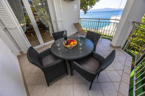 a table with a bowl of fruit on a balcony at Apartmani Heta Alagic I in Selce