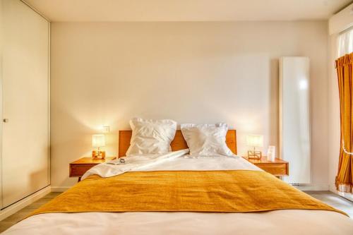 a bedroom with a large bed with two lamps at - Le Maréchal- Port de Vannes in Vannes