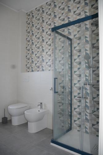 a bathroom with a toilet and a glass shower at WalMarhouse in Taranto