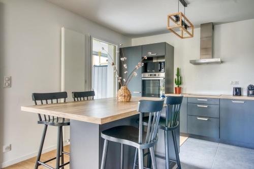 a kitchen with blue cabinets and a wooden island with bar stools at - Le Maréchal- Port de Vannes in Vannes