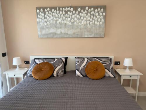 a bedroom with a bed with two orange pillows at Salix Aurea in San Martino Siccomario
