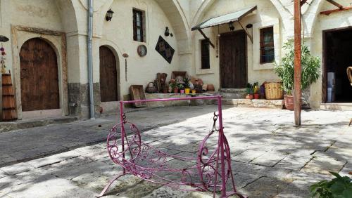 a pink metal chair in front of a building at ARMEsos Cave Hotel in Urgup