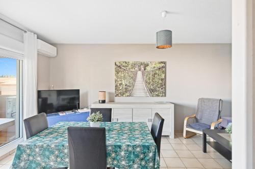 une salle à manger avec une table et une télévision dans l'établissement Hyères Proche Centre - Appartement 1 chambre Clim Pk WIFI BY HC, à Hyères