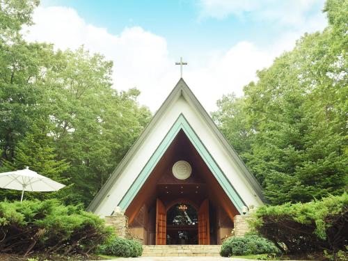 a small church with a cross on top of it at Hotel Epinard Nasu in Nasu