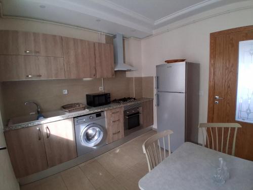 a kitchen with a refrigerator and a table with chairs at Luxurious apartment Jardin Carthage - 2 bedrooms in Sidi Daoud