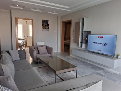 a living room with a couch and a tv at Luxurious apartment Jardin Carthage - 2 bedrooms in Sidi Daoud