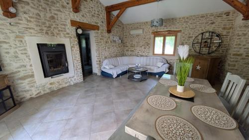a living room with a table and a fireplace at Mas en Pierre "entre Gard et Ardèche" avec jardin in Saint-Victor-de-Malcap