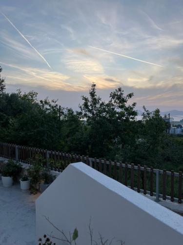 a white bench sitting on top of a fence at sunny rock 2 apartments in Lagoúdi Zía