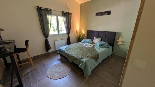 a small bedroom with a bed and a window at Mas en Pierre "entre Gard et Ardèche" avec jardin in Saint-Victor-de-Malcap
