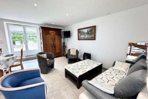 un salon avec un canapé, des chaises et une table dans l'établissement Maison de charme confort - Terrasse - Jardin, à Pont-Scorff