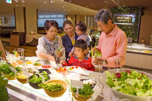 a group of people standing around a table with food at Hotel Epinard Nasu in Nasu