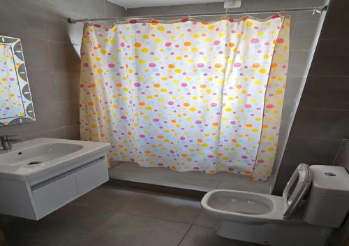 a bathroom with a shower curtain and a toilet at شاليه إطلالة مميزة in El Alamein