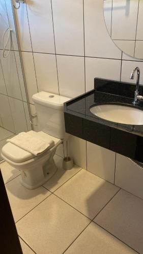 a bathroom with a toilet and a sink at Pousada Encantos de Palmeiras in Palmeiras