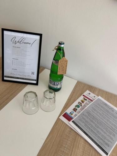 a bottle of wine and two glasses on a table at Michi mHOUSE Small apartment in the heart of Castelli Romani in Albano Laziale