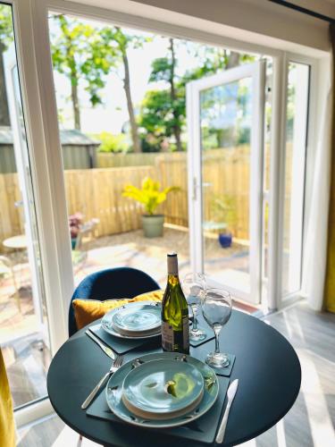 a table with a bottle of wine and glasses on it at Tree View Studio in Ballycastle