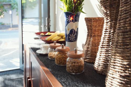 a counter with jars of food and a bowl of fruit at Lily Sands Inn in Melbourne