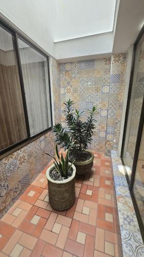 a room with two potted plants on a tile floor at Hotel Imperial in Chiquinquirá