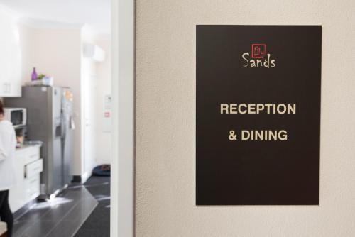 a door with a sign that reads reception and dining at Lily Sands Inn in Melbourne