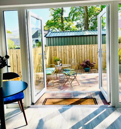 an open door to a patio with a table at Tree View Studio in Ballycastle