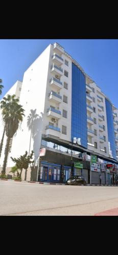 a large building with palm trees in front of it at Ibtissam luxury residence in Larache