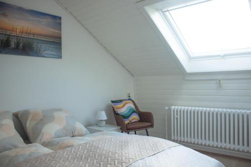 a bedroom with a skylight and a bed and a chair at Ferienhaus Mittendrin zwischen Altstadt und Natur in Celle in Celle