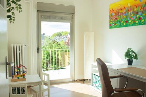 a home office with a desk and a sliding glass door at Ferienhaus Mittendrin zwischen Altstadt und Natur in Celle in Celle