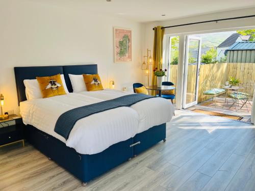 a bedroom with a large bed and a balcony at Tree View Studio in Ballycastle