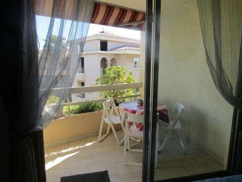 une vue d'un balcon avec une table et des chaises dans l'établissement Studio vue mer en centre ville à 150 m de la plage, à Cavalaire-sur-Mer