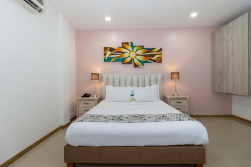 a bedroom with a large bed and two night stands at Hotel Costa Bonita in Montería