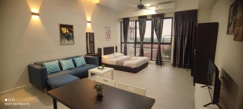 a living room with a couch and a tv at BELL Suites KLIA Comfort Stay - Studio in Sepang
