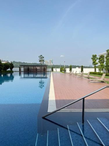 a swimming pool with chairs and water in a building at Suria Garden by Iconique in Puchong